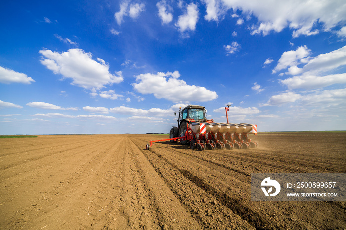 Farmer seeding, sowing crops at field. Sowing is the process of planting seeds in the ground as part of the early spring time agricultural activities.