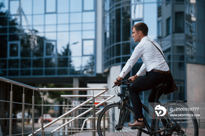 Let’s ride to a job. Businessman in formal clothes with black bicycle is in the city