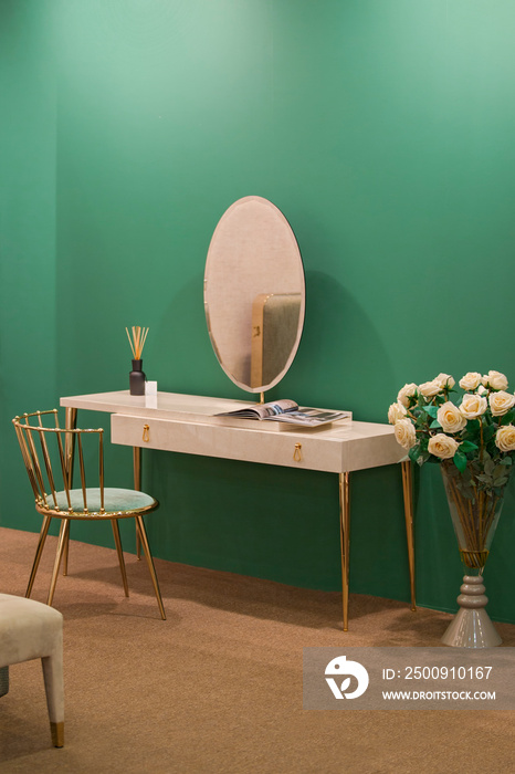White dressing table with wicker elements, a room with a green wall and golden brass furniture, luxu