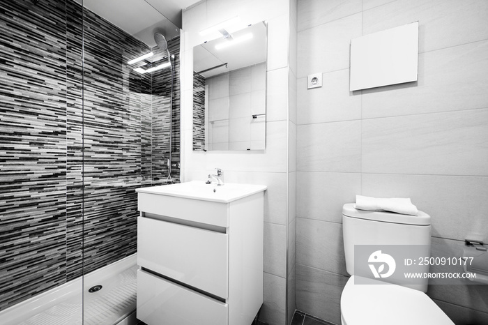 Bathroom with white furniture and white sink tiles, gray tiled wall and frameless mirror