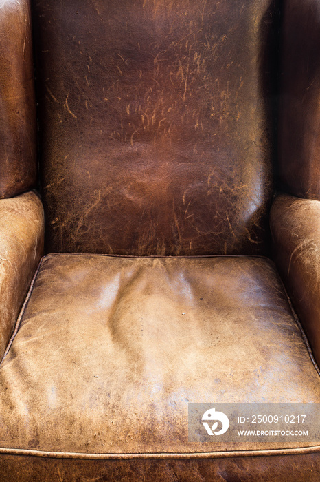 Old leather chair close-up, brown texture, retro design