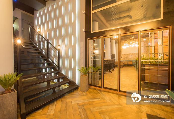 Loft style hall of luxury restaurant with stairs up to second floor