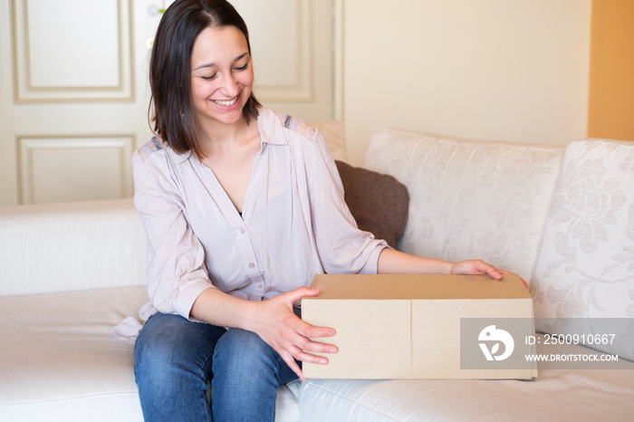 Cheerful woman portrait opening a delivered package