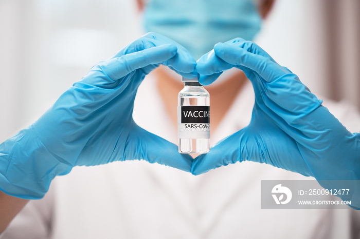 Doctors hand in sterile medical gloves showing heart shape with vaccine COVID-19