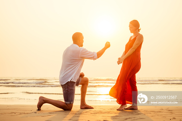 male making proposal with engagement ring to his girlfriend at sea beach.Valentines Day February 14