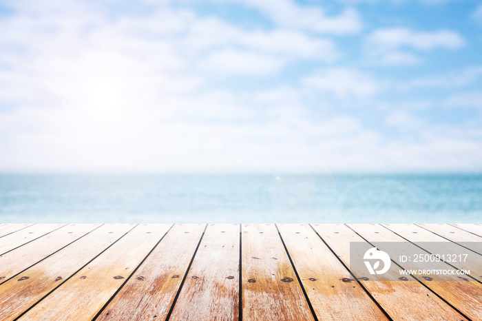 Empty wooden table with party on beach blurred background in summer time.