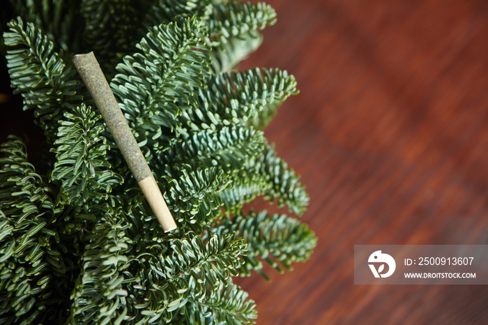 Closeup of a marijuana blunt on the branches of a Christmas tree