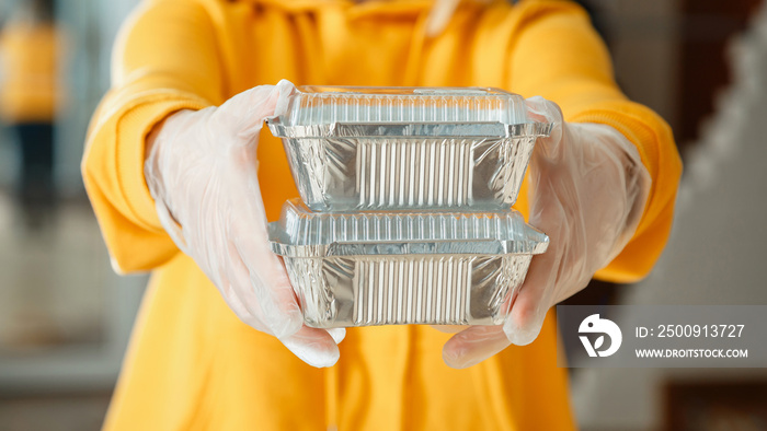 Metal takeaway food container to go. Takeaway Food delivery. Woman in gloves work with takeaway orde