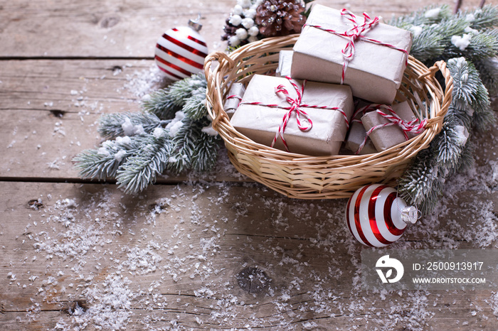 Christmas presents in basket, fur tree and decorative balls on a