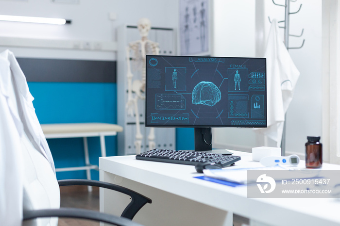 Computer standing on desk in empty bright clinical office having body radiography on screen during m