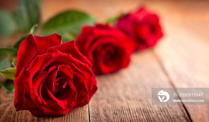 Red roses on wooden background