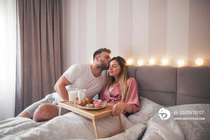 Couple having breakfast in bed.