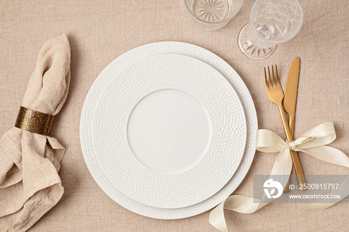 Festive wedding, birthday table setting with golden cutlery and porcelain plate. Empty plate mockup.