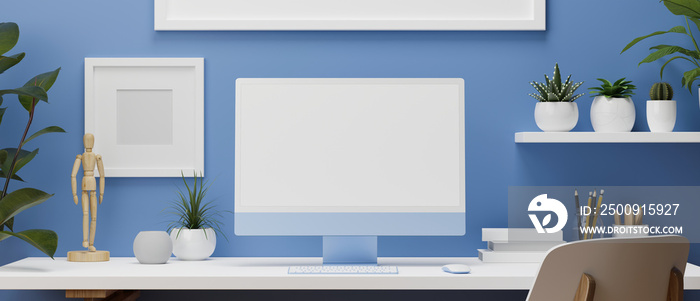 Blue wall working room with computer monitor, white desk and office supplies