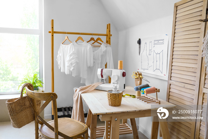 Table with sewing machine and tailors supplies in atelier