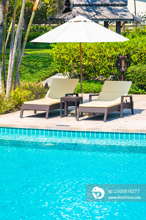 Outdoor swimming pool with sea ocean beach around umbrella and chair