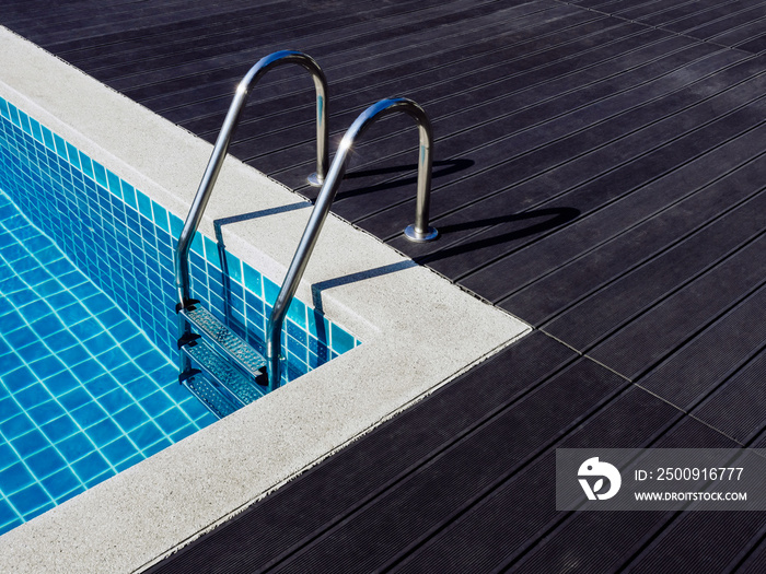 Stone edge frame on the square swimming pool with clean clear water, nobody. Square shaped pool with