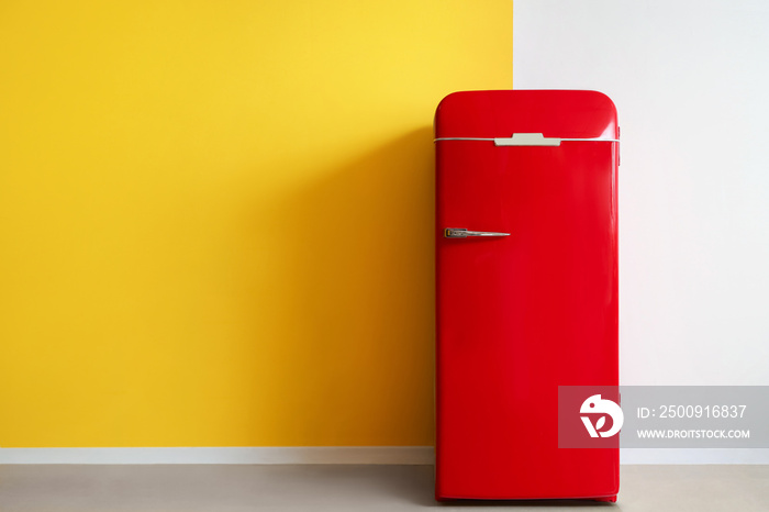 Red fridge near yellow and white wall