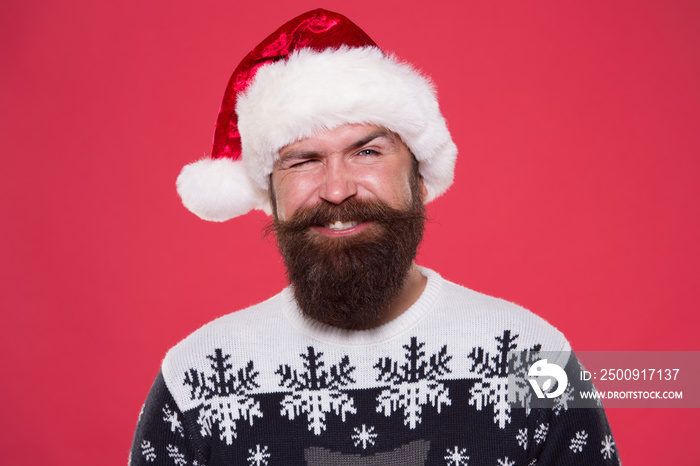 christmas time. smiling bearded man santa hat. brutal hipster favorite sweater red background. winte