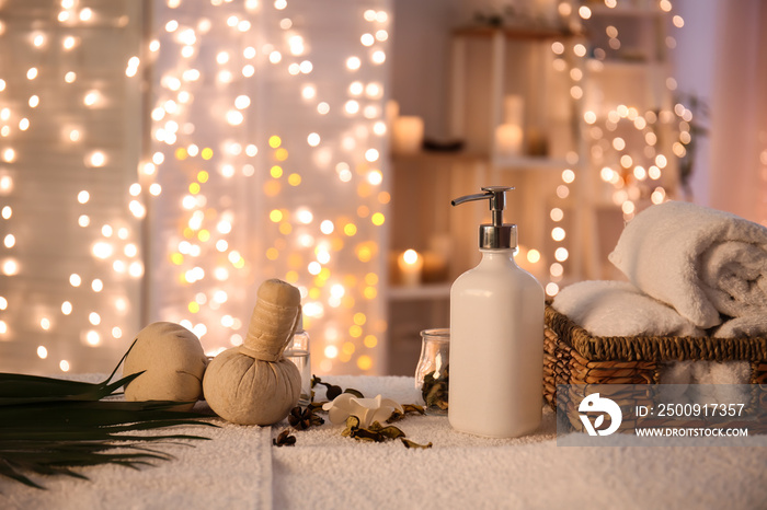 Towels, cosmetics and herbal bags on table in spa salon