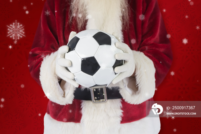 Santa holds a classic football  against red snowflake background