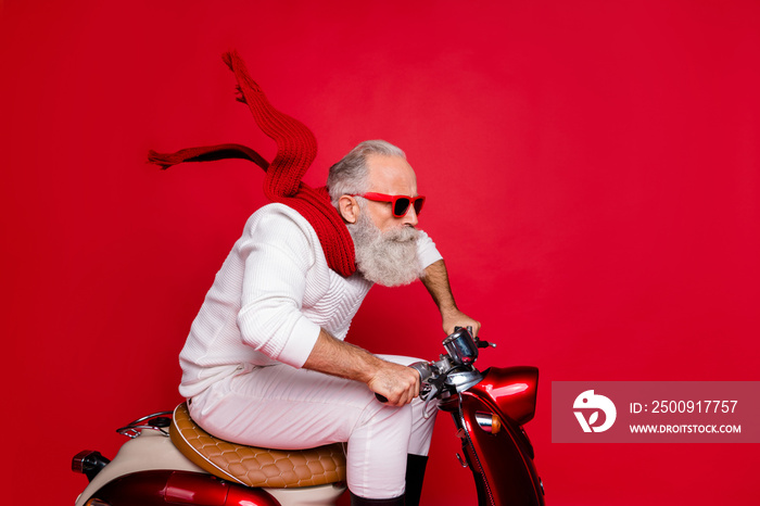 Elderly santa man moving fast to party by vintage moped wear white jumper and trousers isolated red 