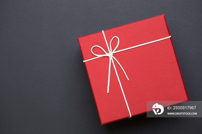 Top view of red gift box on black background with empty space for text information