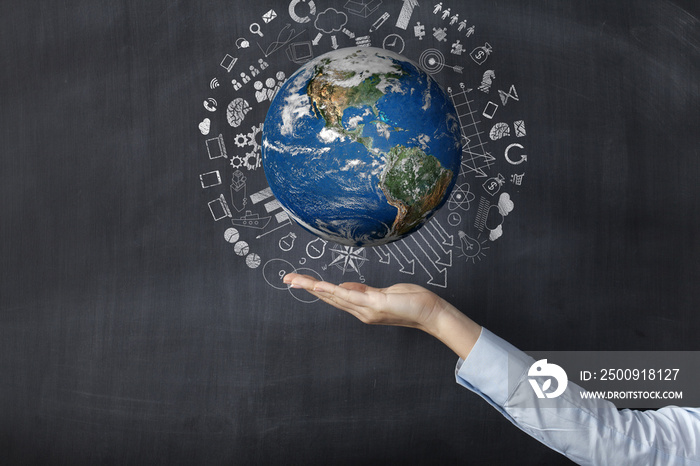 Woman holding earth front of blackboard