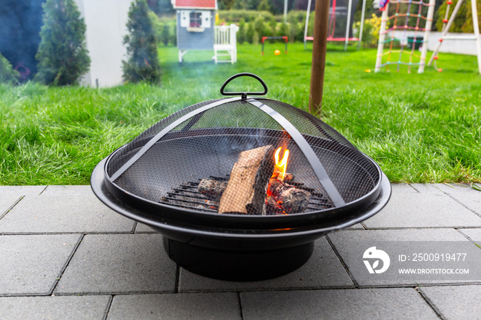 A garden fireplace with a lit wood