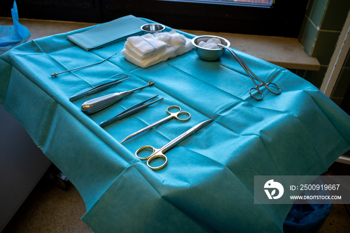 in operating room there is an instrument table with surgical instruments