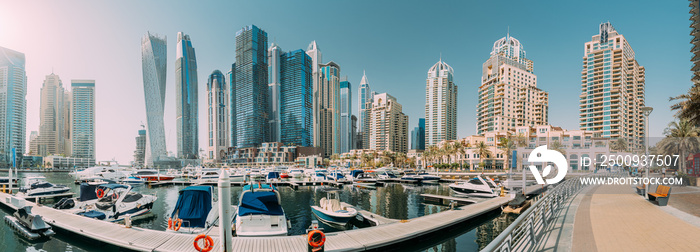 Yachts are moored at city pier, jetty in Dubai Marina. Cityscape skyline. Panorama, panoramic view of glass skyscrapers in Dubai.