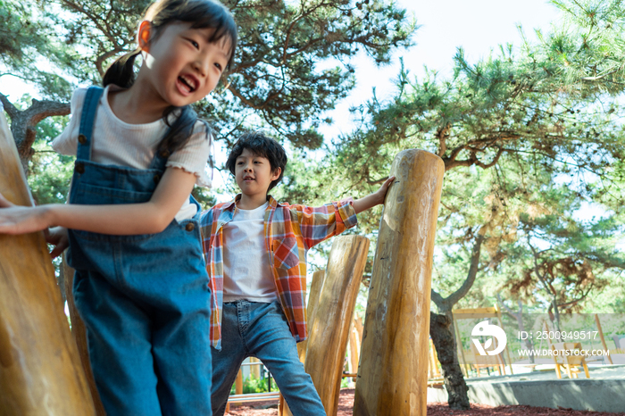 两个小孩子一起走木桩