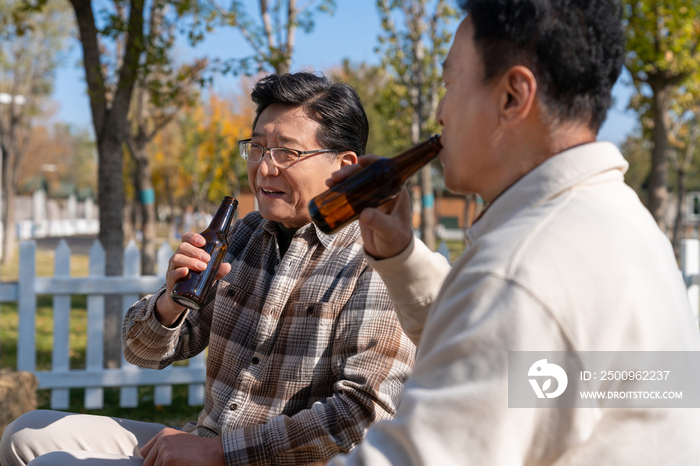 两个老年男人坐在露营地喝啤酒