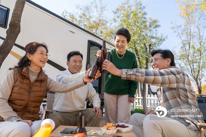 一群中老年人坐在房车露营地喝啤酒聊天