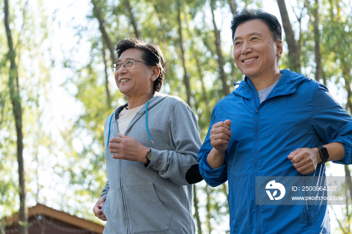 两个戴运动手表的中老年男人在树林跑步健身