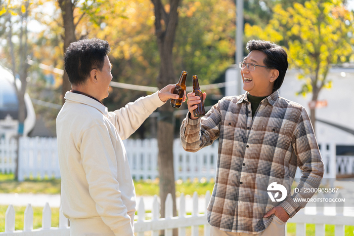 两个老年男人站在露营地喝啤酒