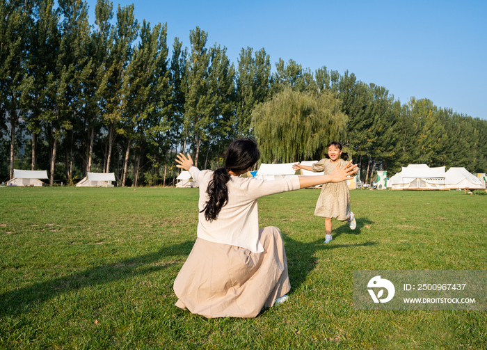 妈妈和女儿在草地上做游戏