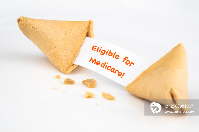 CRACKED FORTUNE COOKIE WITH WORD  Eligible for Medicare!  ON WHITE SLIP PAPER / HEALTH CARE CONCEPT