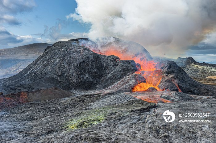 Flowing lava from a volcano in Iceland. Volcanic landscape on the Reykjanes Peninsula. cold, gray, reddish, green igneous rock around the volcano. Steam development over the volcanic crater.