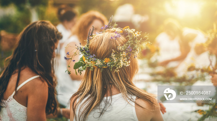 View of women making wreaths with beautiful flowers.