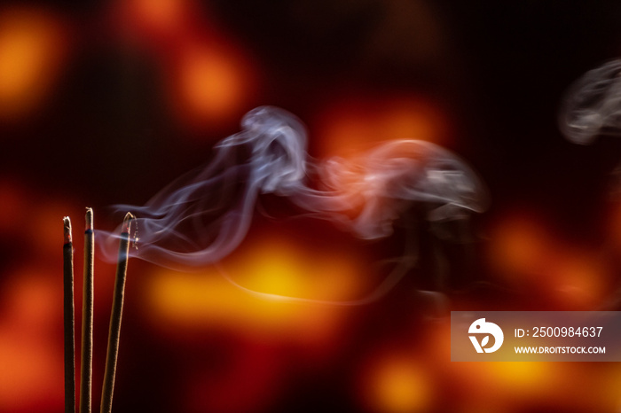 Burning Incense Sticks with smoke, joss sticks burning at a vintage Buddhist temple