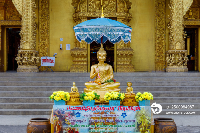 Golden buddha statue under the umbrella in songrand festival at Sri Pan Ton temple Nan district, thailand