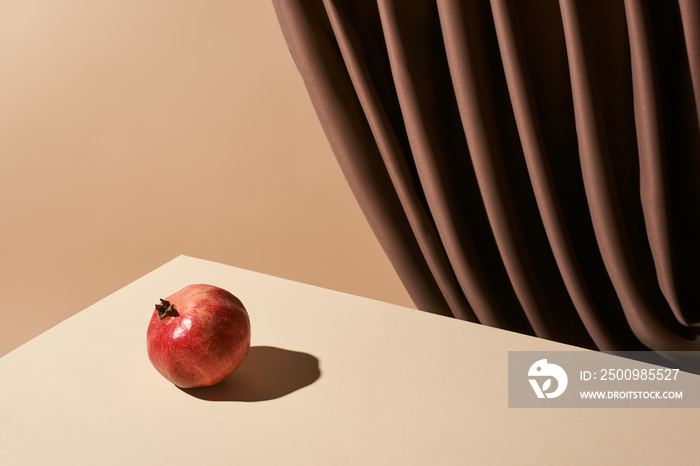 classic still life with pomegranate on table near curtain isolated on beige