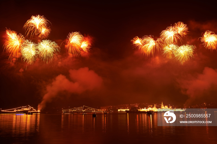 Fireworks on the black sky background and water reflection