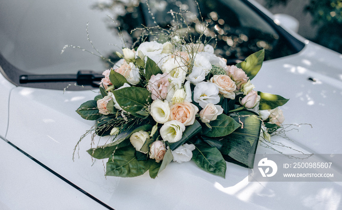 Wedding bouquet on the hood of a white retro car