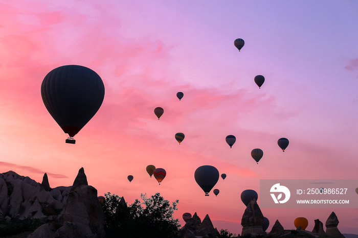 Hot air ballons flying over Cappadocia in sunrise sky, Turkey.