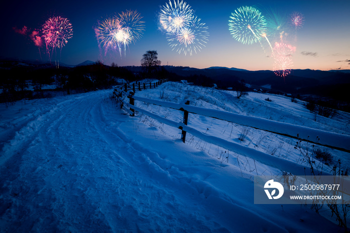 New Years firework display in winter alpine mountain landscape.