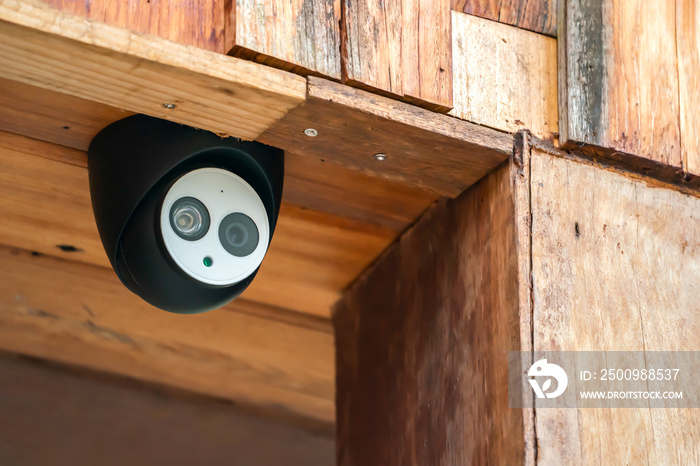 close up mini CCTV camera black case is set up on the wood ceiling building.