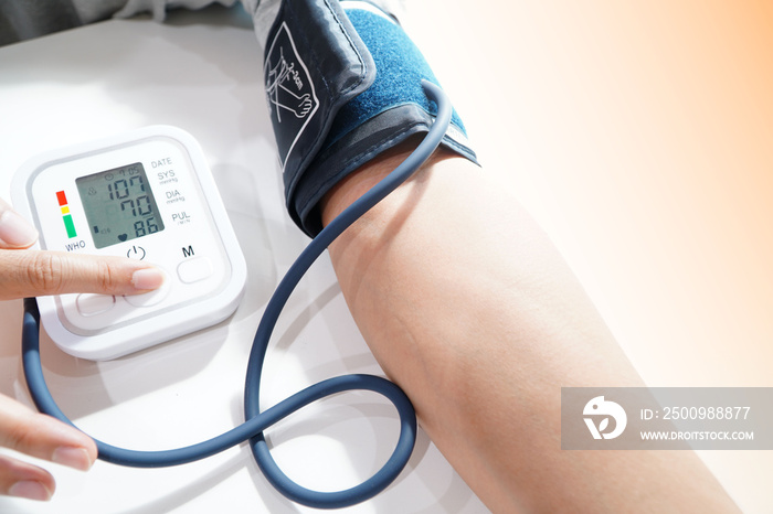 Monitoring blood pressure of patients using upper arm blood pressure monitor in the clinic examination room.