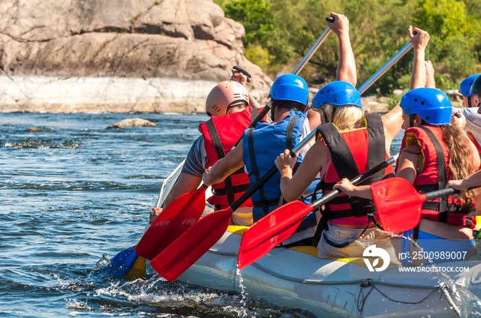 Rafting along the rough river rapids. Extreme vacation in nature.